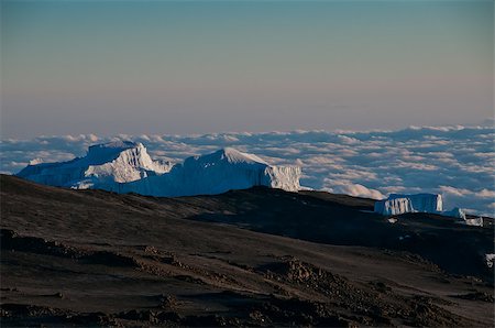 High above the clouds the early morning sun beginning to appear on the glaciers on the crater rim of Kilimanjaro Foto de stock - Super Valor sin royalties y Suscripción, Código: 400-07167754