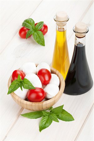 simsearch:400-08071423,k - Mozzarella cheese with cherry tomatoes, basil and olive oil with vinegar on white wood table Foto de stock - Royalty-Free Super Valor e Assinatura, Número: 400-07168675