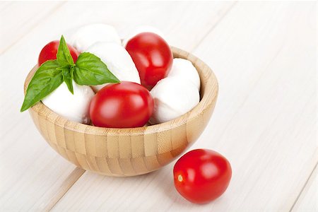 simsearch:400-07172265,k - Mozzarella cheese with cherry tomatoes and basil on white wood table Foto de stock - Royalty-Free Super Valor e Assinatura, Número: 400-07168677