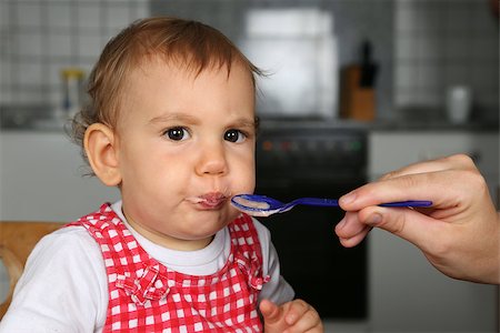 Little Baby girl eating porridge, its mother is feeding her Stock Photo - Budget Royalty-Free & Subscription, Code: 400-07169078