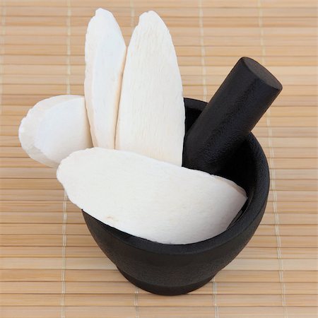 simsearch:400-07174356,k - Discoria used in chinese herbal medicine in a black stone mortar with pestle over bamboo. Shan yao. Discorea opposita. Stock Photo - Budget Royalty-Free & Subscription, Code: 400-07169421