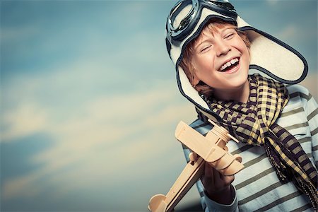Laughing boy with plane on the background of sky Stock Photo - Budget Royalty-Free & Subscription, Code: 400-07169514