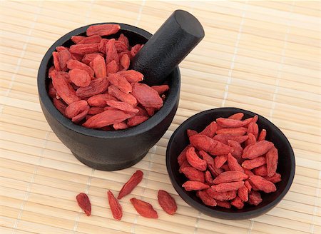 simsearch:400-07174356,k - Wolfberry fruit used in chinese herbal medicine in a mortar with pestle and bowl over bamboo. Gou qi zi. Stock Photo - Budget Royalty-Free & Subscription, Code: 400-07174356