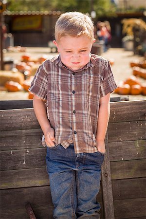 simsearch:614-03818705,k - Frustrated Little Boy at Pumpkin Patch Farm Standing Against Old Wood Wagon. Fotografie stock - Microstock e Abbonamento, Codice: 400-07174828