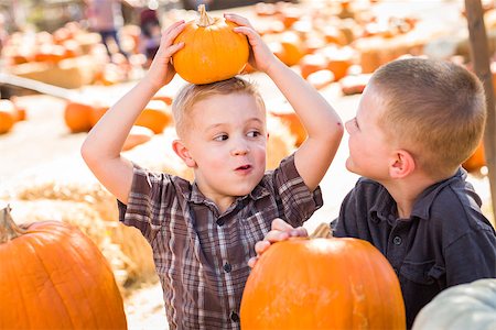 simsearch:400-07179959,k - Two Boys at the Pumpkin Patch Talking About Their Pumpkins and Having Fun on a Fall Day. Stockbilder - Microstock & Abonnement, Bildnummer: 400-07174820
