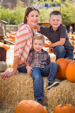 simsearch:400-07173767,k - Attractive Mother and Her Two Sons Pose for a Portrait in a Rustic Ranch Setting at the Pumpkin Patch. Foto de stock - Royalty-Free Super Valor e Assinatura, Número: 400-07174823