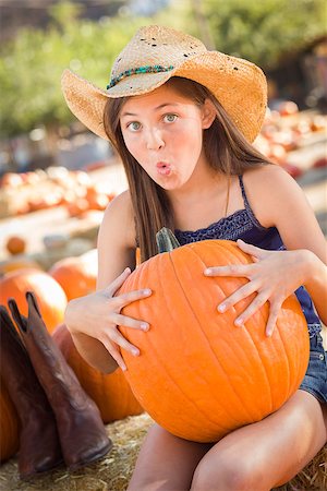 simsearch:400-07173767,k - Preteen Girl Holding A Large Pumpkin at the Pumpkin Patch in a Rustic Setting. Foto de stock - Royalty-Free Super Valor e Assinatura, Número: 400-07174842
