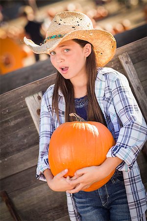 simsearch:400-07173780,k - Preteen Girl Wearing Cowboy Hat Portrait at the Pumpkin Patch in a Rustic Setting. Stockbilder - Microstock & Abonnement, Bildnummer: 400-07174850