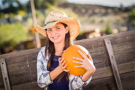 simsearch:400-07179959,k - Preteen Girl Wearing Cowboy Hat Portrait at the Pumpkin Patch in a Rustic Setting. Stockbilder - Microstock & Abonnement, Bildnummer: 400-07174860