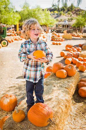 simsearch:400-07179959,k - Adorable Little Boy Sitting and Holding His Pumpkin in a Rustic Ranch Setting at the Pumpkin Patch. Stockbilder - Microstock & Abonnement, Bildnummer: 400-07176168