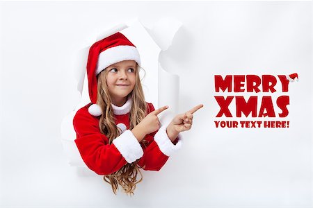 Santa girl pointig to copy space - leaning through hole in paper Stock Photo - Budget Royalty-Free & Subscription, Code: 400-07176678