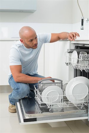 Serious young man using dish washer in the kitchen at home Stock Photo - Budget Royalty-Free & Subscription, Code: 400-07177494