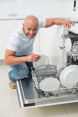 simsearch:400-07177497,k - Portrait of a smiling young man using dish washer in the kitchen at home Foto de stock - Super Valor sin royalties y Suscripción, Código: 400-07177496