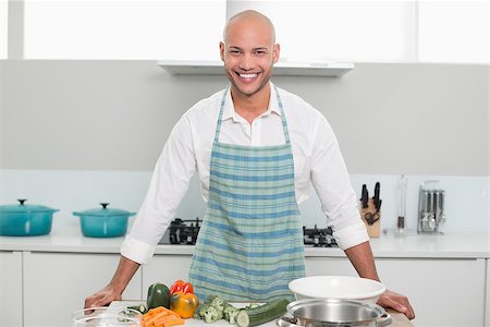 simsearch:400-07177497,k - Portrait of a smiling young man with vegetables standing in the kitchen at home Foto de stock - Super Valor sin royalties y Suscripción, Código: 400-07177491