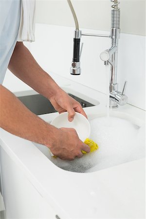 simsearch:400-07228658,k - Close up mid section of a man doing the dishes at kitchen sink in the house Stockbilder - Microstock & Abonnement, Bildnummer: 400-07177528