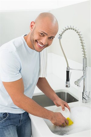 simsearch:400-07228658,k - Portrait of a smiling young man doing the dishes at kitchen sink in the house Stockbilder - Microstock & Abonnement, Bildnummer: 400-07177530