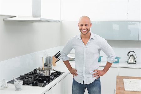 simsearch:400-07177497,k - Portrait of a smiling young man besides stove in the kitchen at home Foto de stock - Super Valor sin royalties y Suscripción, Código: 400-07177540
