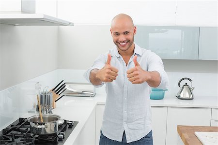 simsearch:400-07177497,k - Portrait of a smiling young man gesturing thumbs up in the kitchen at home Foto de stock - Super Valor sin royalties y Suscripción, Código: 400-07177541