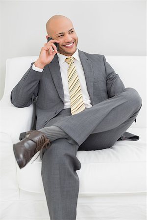 sophisticated home smile - Smiling elegant young businessman using cellphone on sofa at home Stock Photo - Budget Royalty-Free & Subscription, Code: 400-07177608