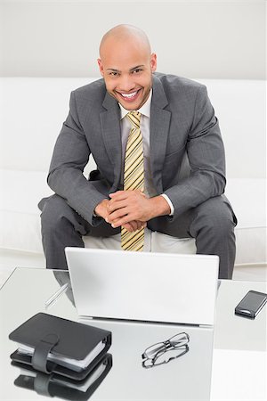 sophisticated home smile - Portrait of a smiling elegant young businessman with laptop on sofa at home Stock Photo - Budget Royalty-Free & Subscription, Code: 400-07177602