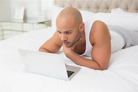 simsearch:400-07177497,k - Casual bald young man using laptop in bed at home Foto de stock - Super Valor sin royalties y Suscripción, Código: 400-07177711