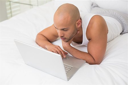 simsearch:400-07177497,k - Casual bald young man using laptop in bed at home Foto de stock - Super Valor sin royalties y Suscripción, Código: 400-07177712