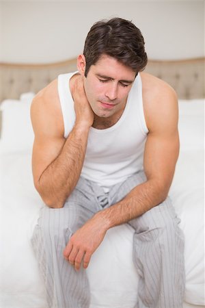 simsearch:695-05769616,k - Young man suffering from neck ache in bed at home Stock Photo - Budget Royalty-Free & Subscription, Code: 400-07177764