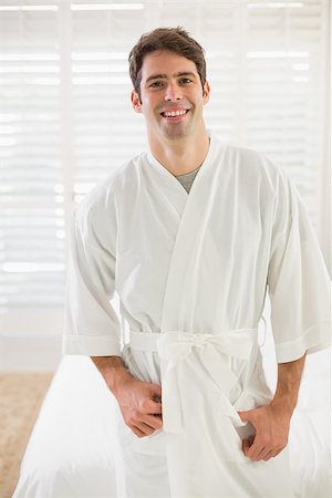 Portrait of a young smiling man in bathrobe standing in bedroom at home Stock Photo - Budget Royalty-Free & Subscription, Code: 400-07177835