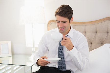 sophisticated home smile - Smiling well dressed man drinking tea in bed at home Stock Photo - Budget Royalty-Free & Subscription, Code: 400-07177910