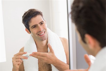 Close up of young man with reflection putting moisturizer on his face Stock Photo - Budget Royalty-Free & Subscription, Code: 400-07177996