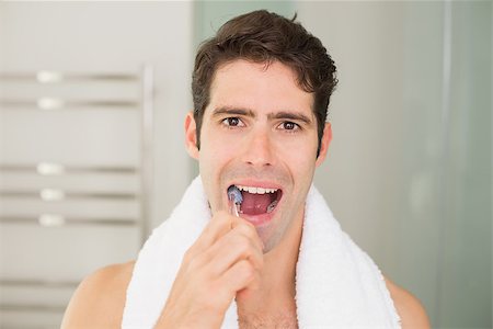 Close up portrait of a young man brushing teeth in the bathroom Stock Photo - Budget Royalty-Free & Subscription, Code: 400-07178006