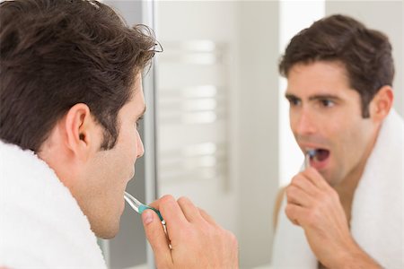 Close up of a young man with reflection brushing teeth in the bathroom Stock Photo - Budget Royalty-Free & Subscription, Code: 400-07178003