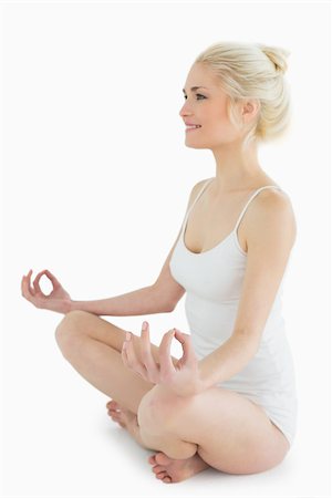 simsearch:400-07135317,k - Full length of a toned young woman sitting in lotus position against white background Photographie de stock - Aubaine LD & Abonnement, Code: 400-07178267