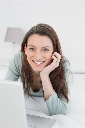 Portrait of a happy relaxed casual young woman using laptop in bed at home Stock Photo - Budget Royalty-Free & Subscription, Code: 400-07178644