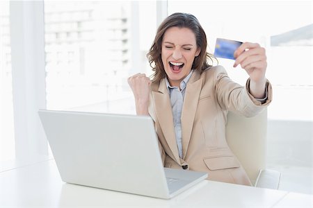 simsearch:400-07333971,k - Excited businesswoman doing online shopping through laptop and credit card in office Stock Photo - Budget Royalty-Free & Subscription, Code: 400-07178838