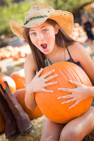 simsearch:400-07173767,k - Preteen Girl Holding A Large Pumpkin at the Pumpkin Patch in a Rustic Setting. Foto de stock - Royalty-Free Super Valor e Assinatura, Número: 400-07179071