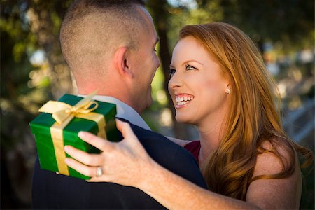 Smiling Beautiful Young Woman and Handsome Military Man Exchange a Christmas Gift. Stock Photo - Budget Royalty-Free & Subscription, Code: 400-07179918