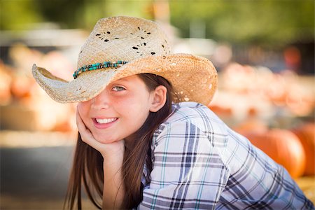 simsearch:400-07173767,k - Preteen Girl Wearing Cowboy Hat Portrait at the Pumpkin Patch in a Rustic Setting. Foto de stock - Royalty-Free Super Valor e Assinatura, Número: 400-07179955