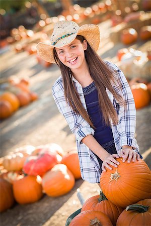 simsearch:400-07173767,k - Preteen Girl Wearing Cowboy Hat Playing with a Wheelbarrow at the Pumpkin Patch in a Rustic Country Setting. Foto de stock - Royalty-Free Super Valor e Assinatura, Número: 400-07179958