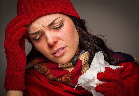 simsearch:400-06462603,k - Sick Mixed Race Woman Wearing Winter Hat and Gloves Blowing Her Sore Nose with a Tissue. Stock Photo - Budget Royalty-Free & Subscription, Code: 400-07170552