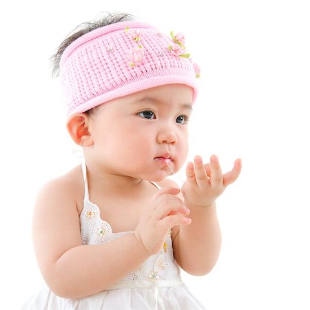 simsearch:400-06389659,k - Portrait of cute Asian baby girl  eating,  isolated on white background Stock Photo - Budget Royalty-Free & Subscription, Code: 400-07171480