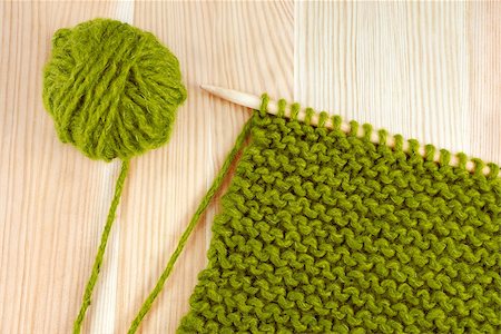 Green ball of wool and garter stitch on a knitting needle, on wooden table Stock Photo - Budget Royalty-Free & Subscription, Code: 400-07171746