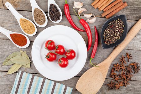 simsearch:400-07172360,k - Colorful herbs and spices selection. Aromatic ingredients on wood table and cherry tomatoes on plate Photographie de stock - Aubaine LD & Abonnement, Code: 400-07172340