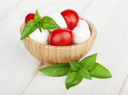 simsearch:400-07172265,k - Mozzarella cheese with cherry tomatoes and basil on white wood table Foto de stock - Royalty-Free Super Valor e Assinatura, Número: 400-07172621