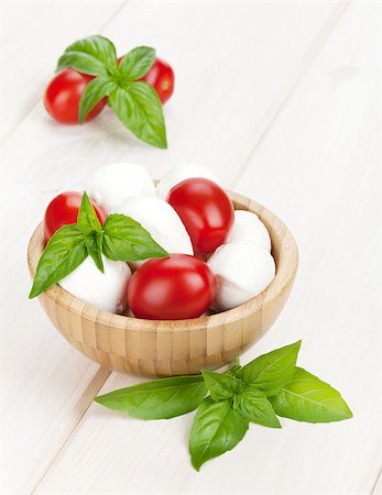 simsearch:400-07172265,k - Mozzarella cheese with cherry tomatoes and basil on white wood table Foto de stock - Royalty-Free Super Valor e Assinatura, Número: 400-07172622