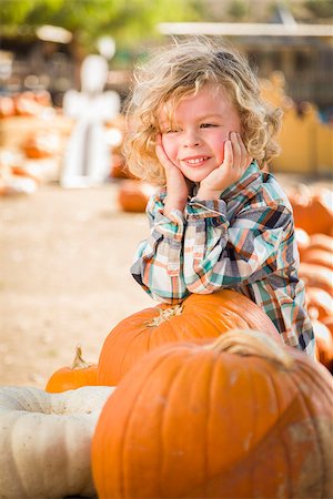 simsearch:400-07179959,k - Adorable Little Boy Smiles While Leaning on a Pumpkin at a Pumpkin Patch in a Rustic Setting. Stockbilder - Microstock & Abonnement, Bildnummer: 400-07173778