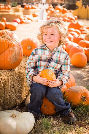 simsearch:400-07173780,k - Adorable Little Boy Sitting and Holding His Pumpkin in a Rustic Ranch Setting at the Pumpkin Patch. Stockbilder - Microstock & Abonnement, Bildnummer: 400-07173770