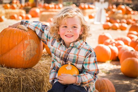 simsearch:400-07179959,k - Adorable Little Boy Sitting and Holding His Pumpkin in a Rustic Ranch Setting at the Pumpkin Patch. Stockbilder - Microstock & Abonnement, Bildnummer: 400-07173771