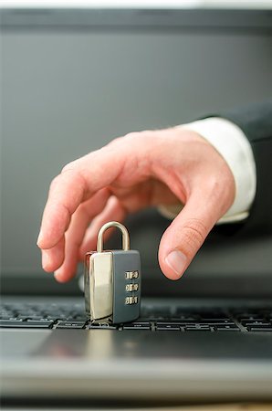 simsearch:649-08765870,k - Hand of a hacker trying to steal a padlock from laptop keyboard. Fotografie stock - Microstock e Abbonamento, Codice: 400-07173967
