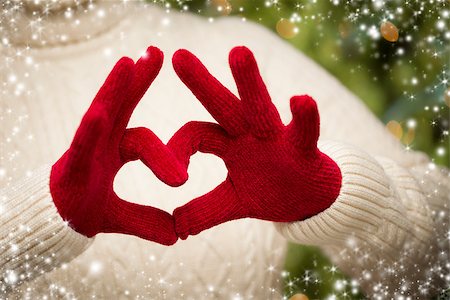 simsearch:400-06462603,k - Woman in Sweater with Seasonal Red Mittens Holding Out a Heart Sign with Her Hands with Snow Flakes Border. Stock Photo - Budget Royalty-Free & Subscription, Code: 400-07184852